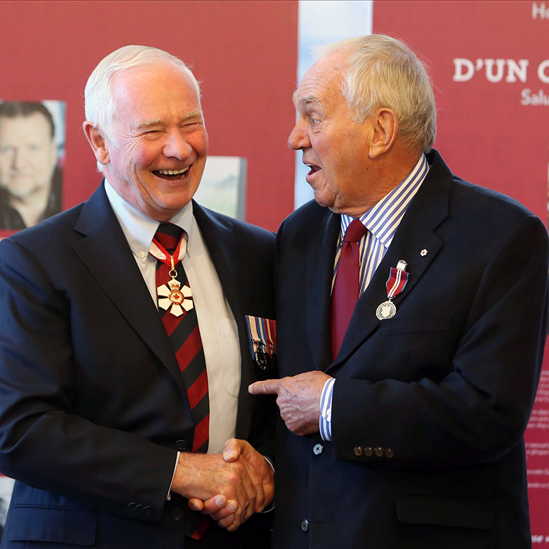 Ed Broadbent and Governor General David Johnston gleefully shaking hands.