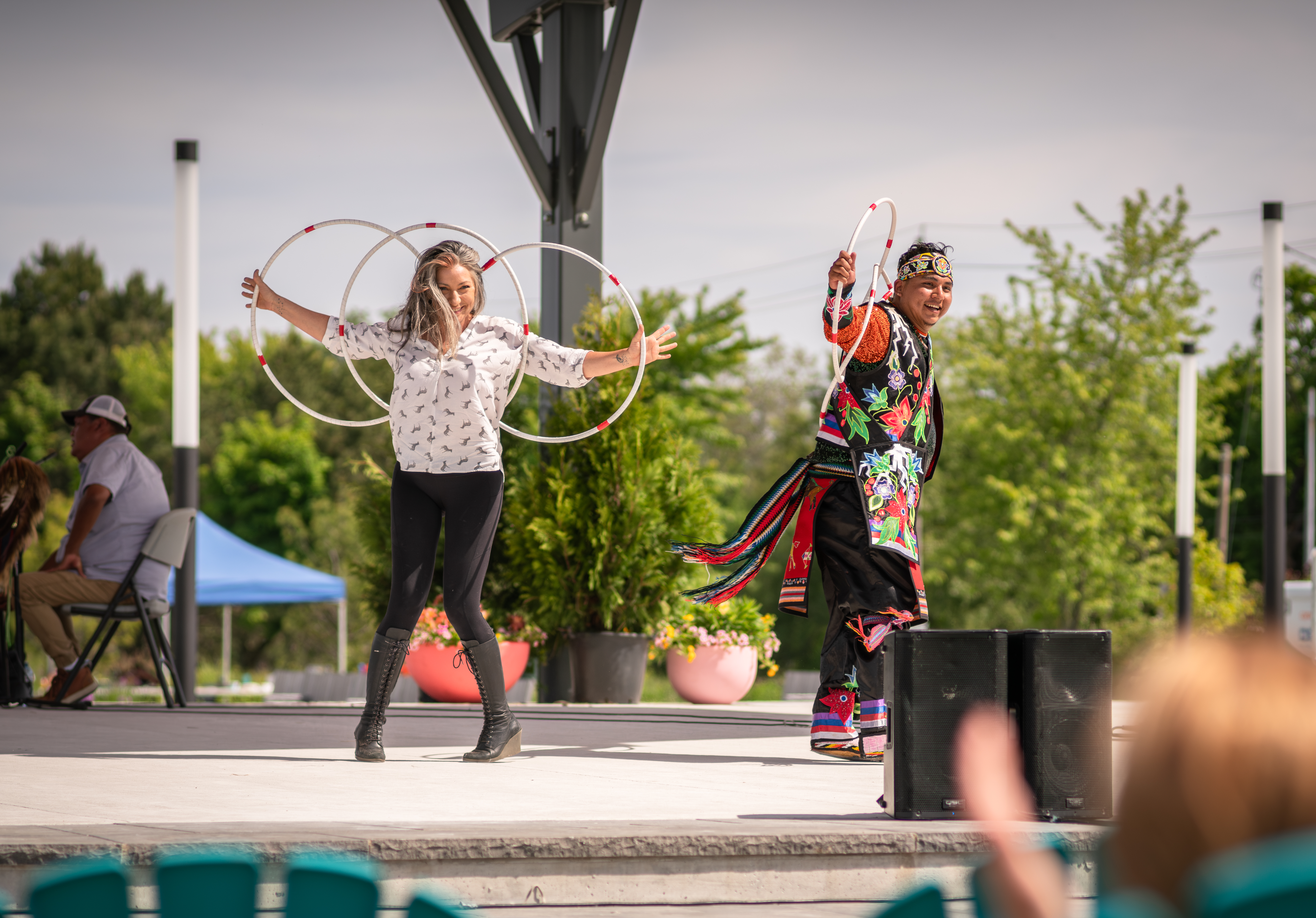 Two people on stage doing a performance with large rings.
